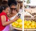 Seller showing an order on her phone to a customer at the market